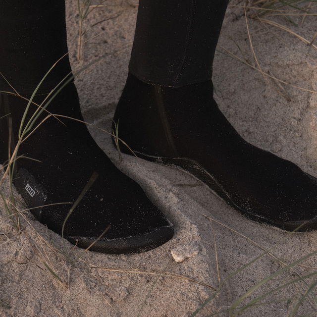 Neoprene Sock Ballistic 3/2 Round Toe worn on sandy ground.