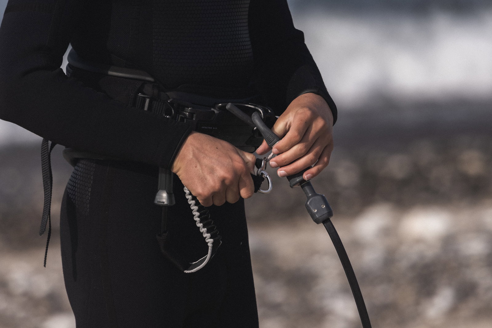 ION Amp Short kite safety leash 55cm in black during kitesurfing at the coast