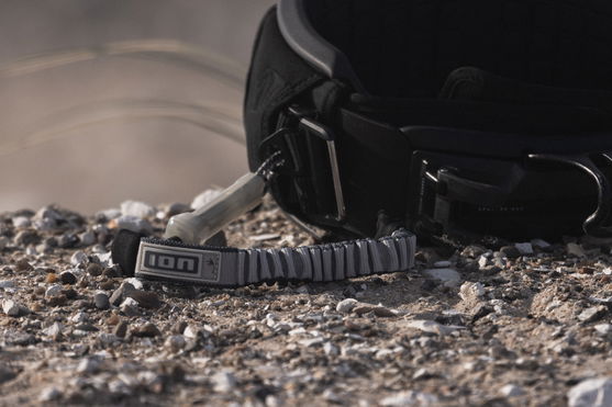 Kite harness with leash on rocky ground.