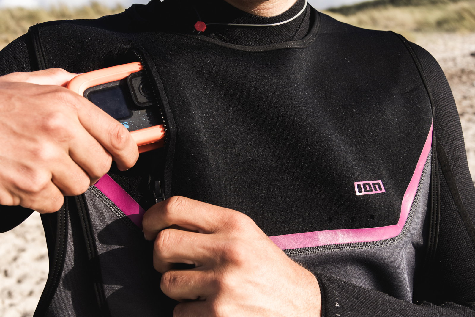 ION Neo Jam water jacket in black and pink – chest pocket detail with action camera during parawinging