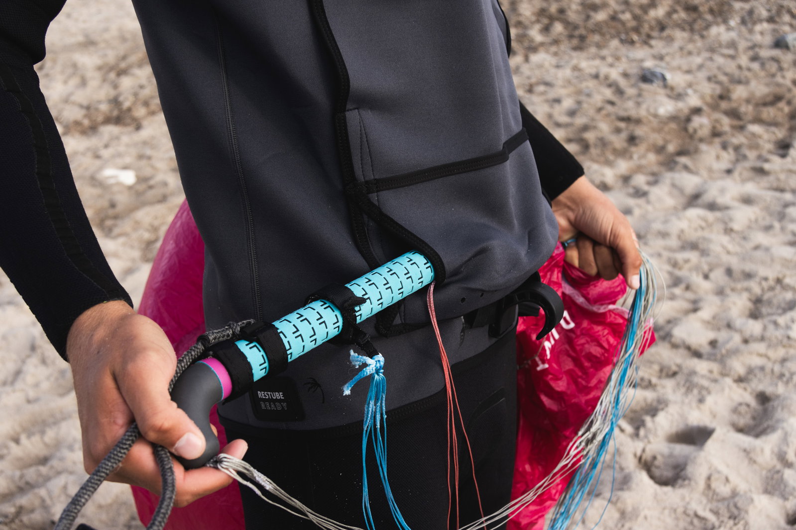 ION Water Neo Jam neoprene jacket in charcoal black during wing foiling on the beach, RESTUBE READY detail