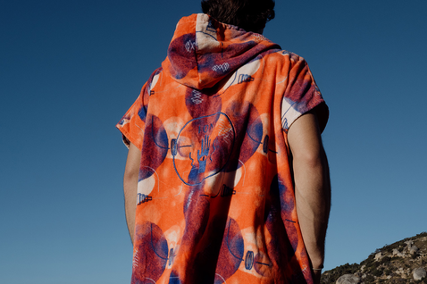 ION Core Lumen surf poncho in burnt orange with all-over print and hood, back view