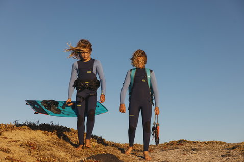 ION Capture 5/4mm Frontzip Junior Neoprenanzug in marineblau und türkis beim Kitesurfen an der Küste
