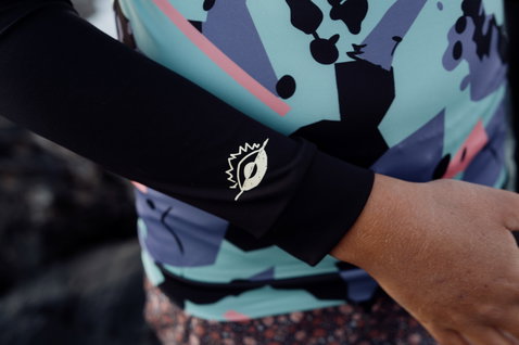 ION Capture Rashguard Langarm für Kinder in schwarz, mint und lavendel – Ärmeldetail mit ION-Logo