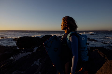 ION Capture 4/3mm Backzip Fullsuit Junior beim Kitesurfen an der Felsenküste bei Sonnenuntergang
