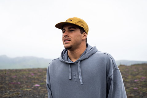 ION Surfing Elements men's hoodie in washed blue-grey worn in a misty coastal landscape