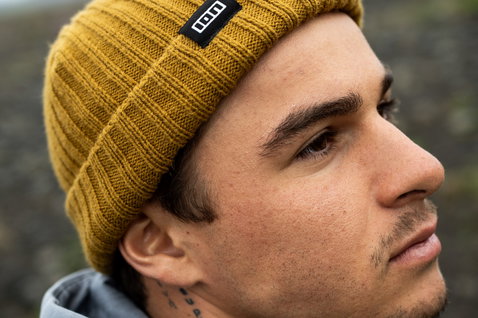 ION Ionic Fisherman Beanie in gold burst indossato da un uomo all'aperto