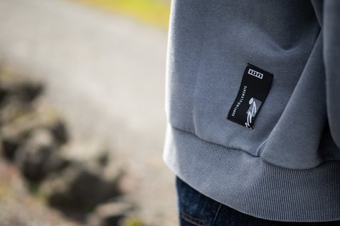 Felpa ION Mood donna in grigio chiaro – dettaglio patch Surfing Elements sull'orlo