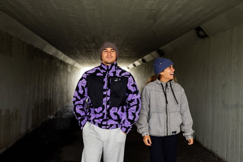 ION Jacket HD Insulated Cotton unisex jacket in purple-black and light grey worn by two models in an urban tunnel