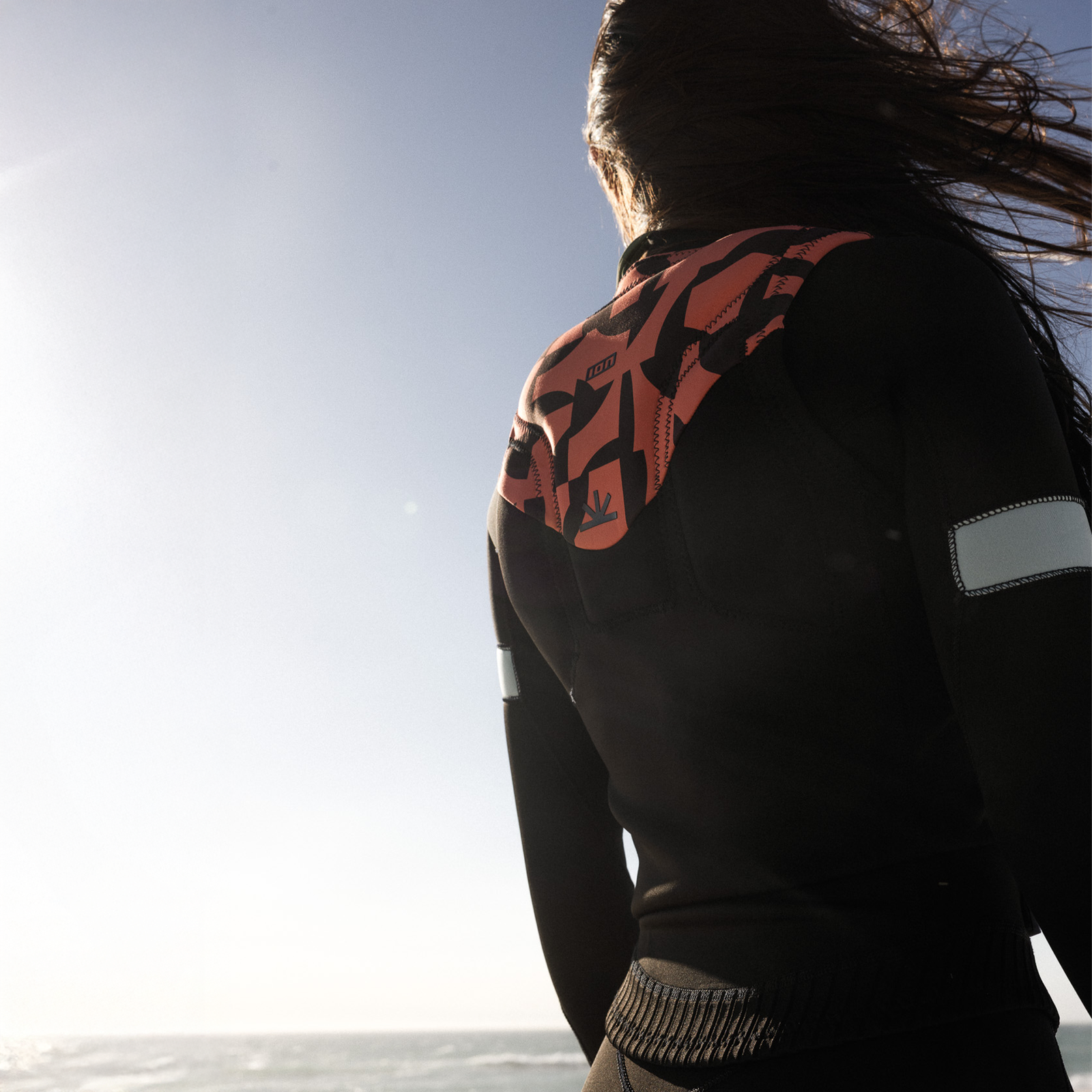 ION Ivy Impact Vest Damen Front Zip in schwarz, coral mit Tiger-Print – Rückansicht beim Kitesurfen