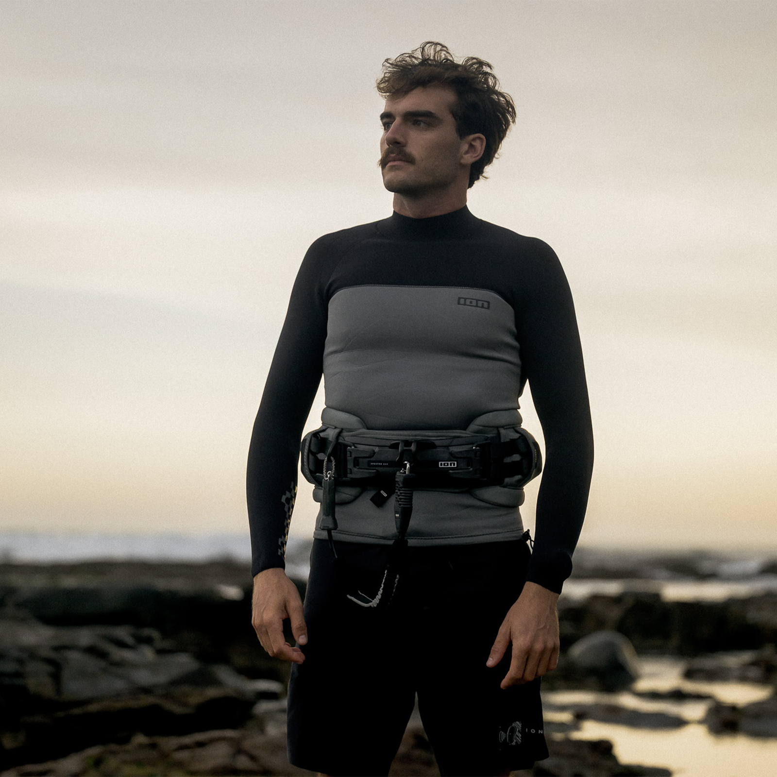 ION Apex waist harness in sage grey during kitesurfing at the coast with Ergo Pad lumbar support
