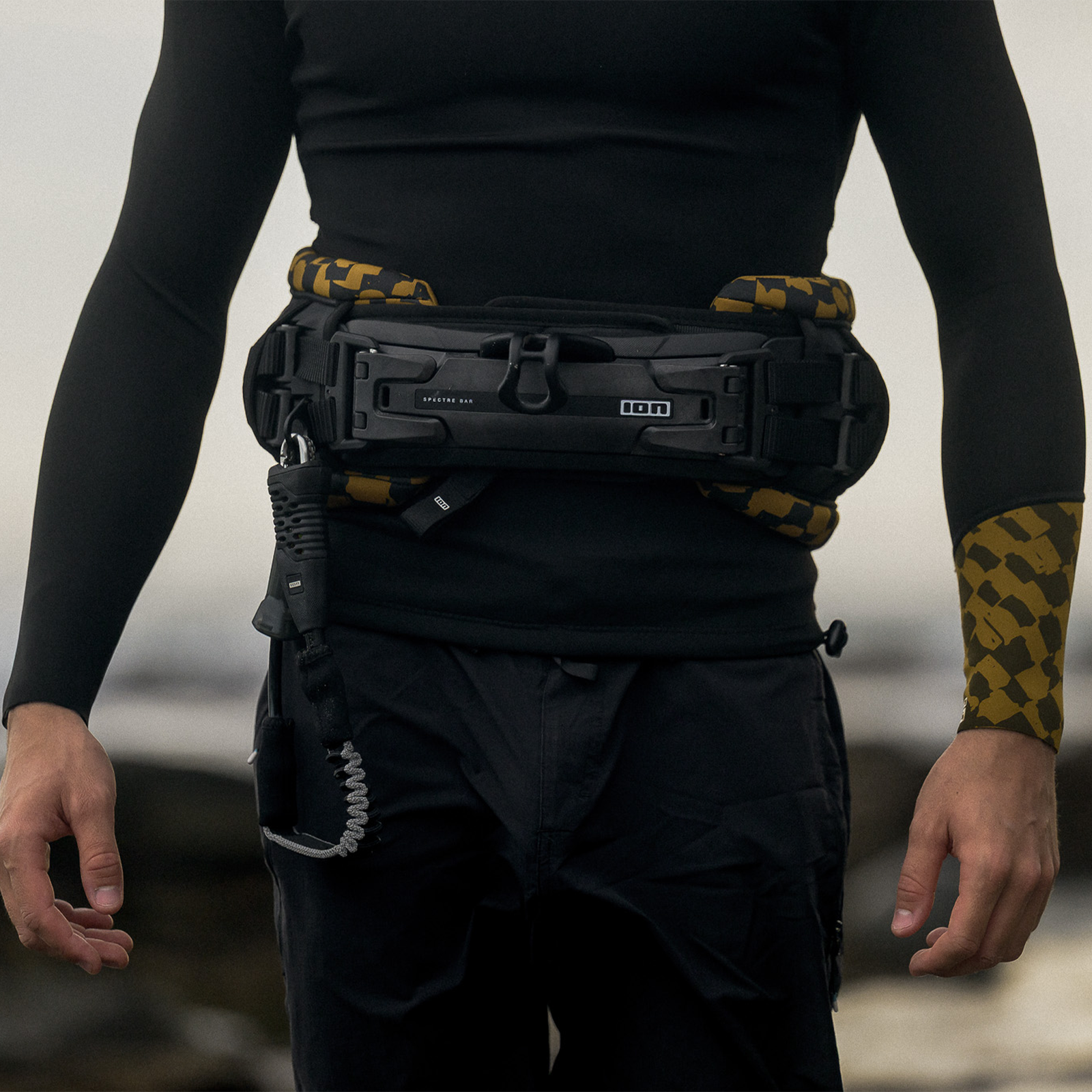 ION Riot Curv waist harness in black and gold with CURV hard shell, worn front view