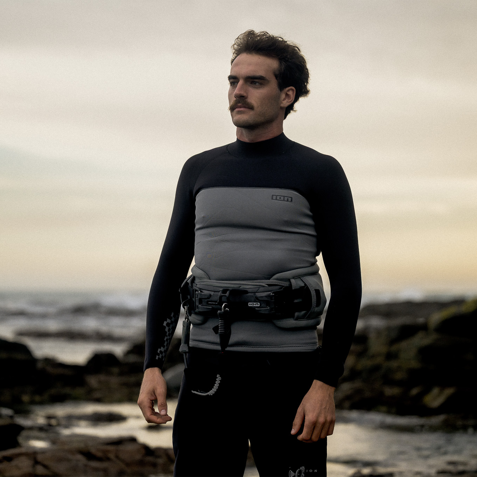 ION Rival waist harness in sage grey worn at rocky coastal beach