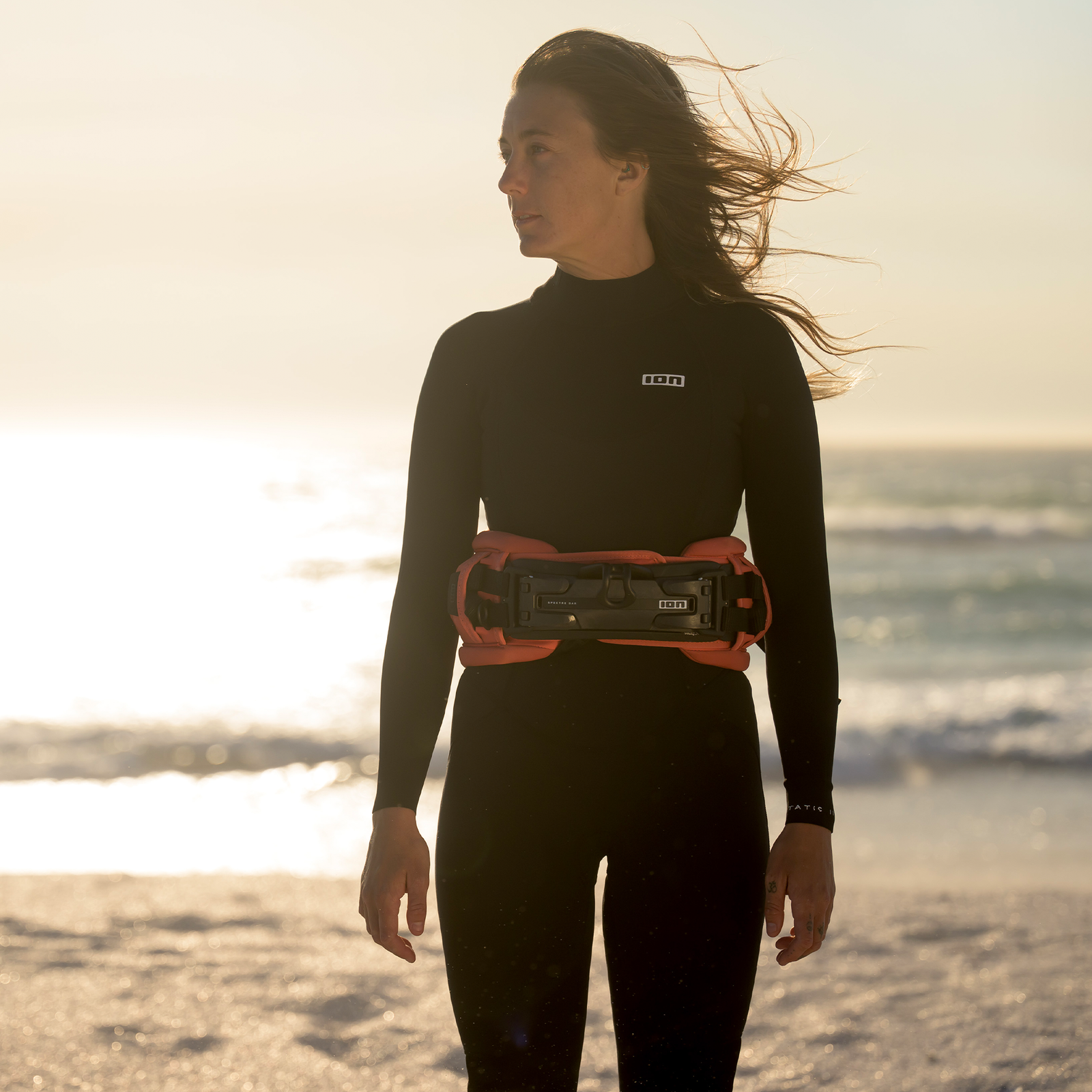 ION Muse women's waist harness in tiger coral with Spectre Bar 2 at the beach