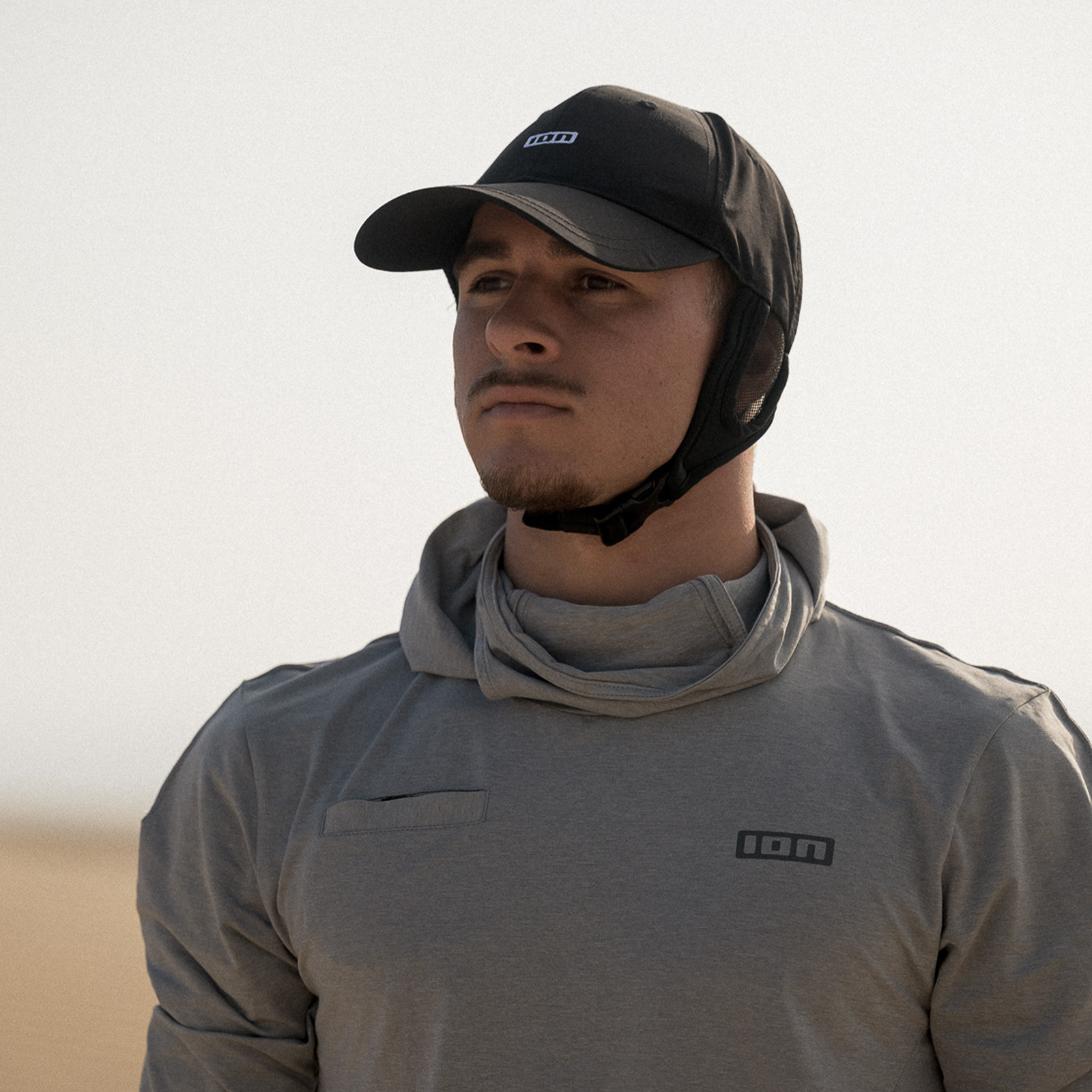 ION Surf Cap neoprene water cap with integrated hood in black during kitesurfing