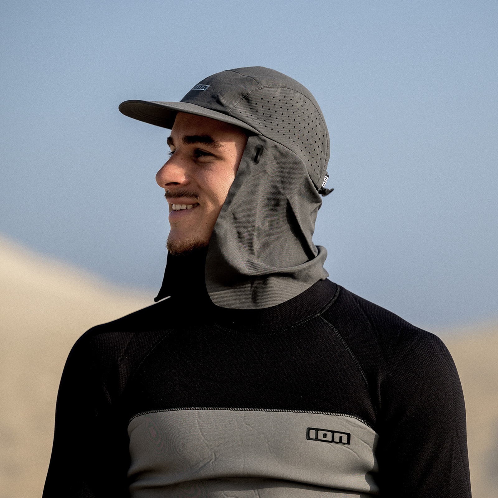 ION Water Surf Cap PRO cappellino acquatico in grigio con protezione nuca indossato durante gli sport acquatici