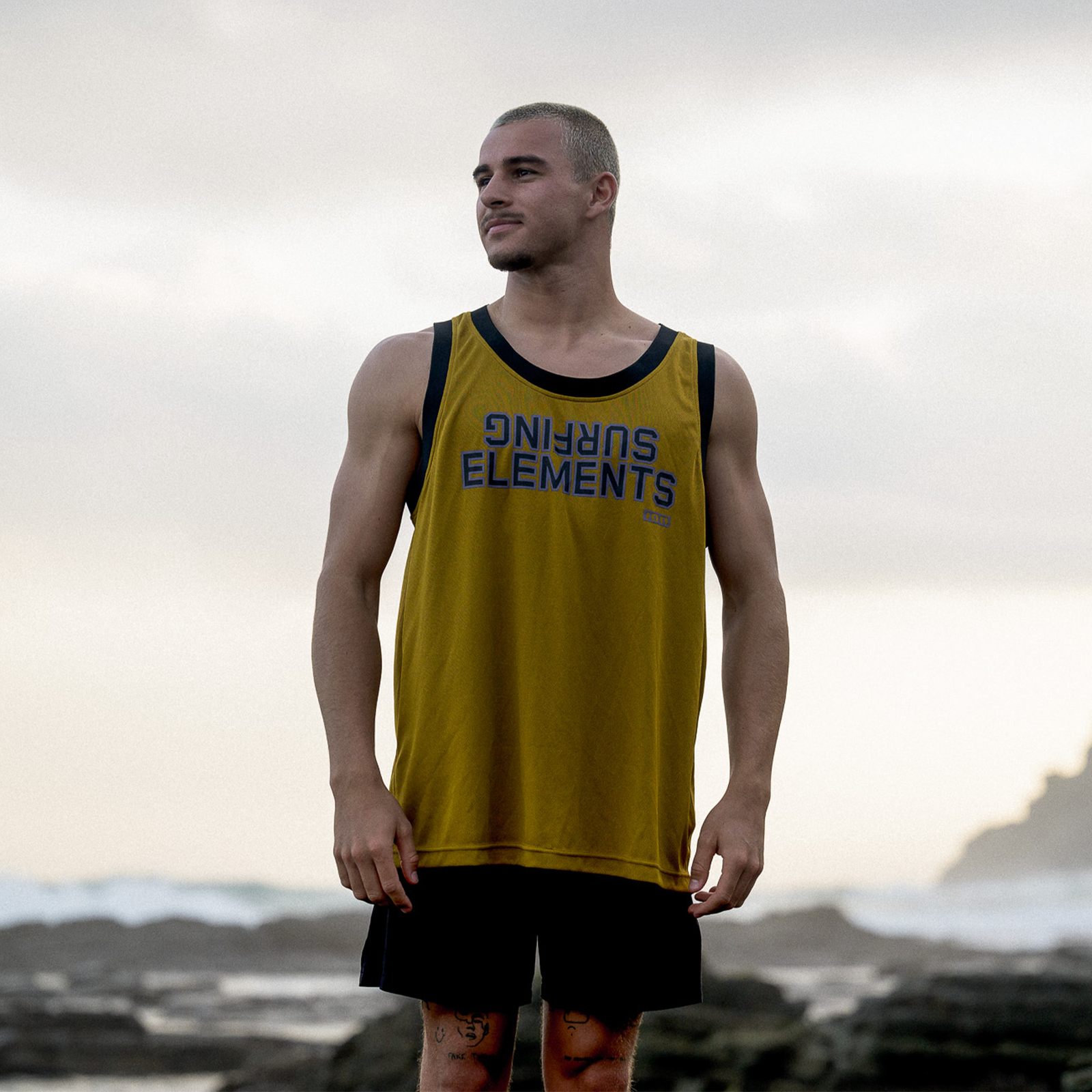 ION Water Wetshirt Basketball débardeur homme en doré avec bordure noire, porté en bord de mer