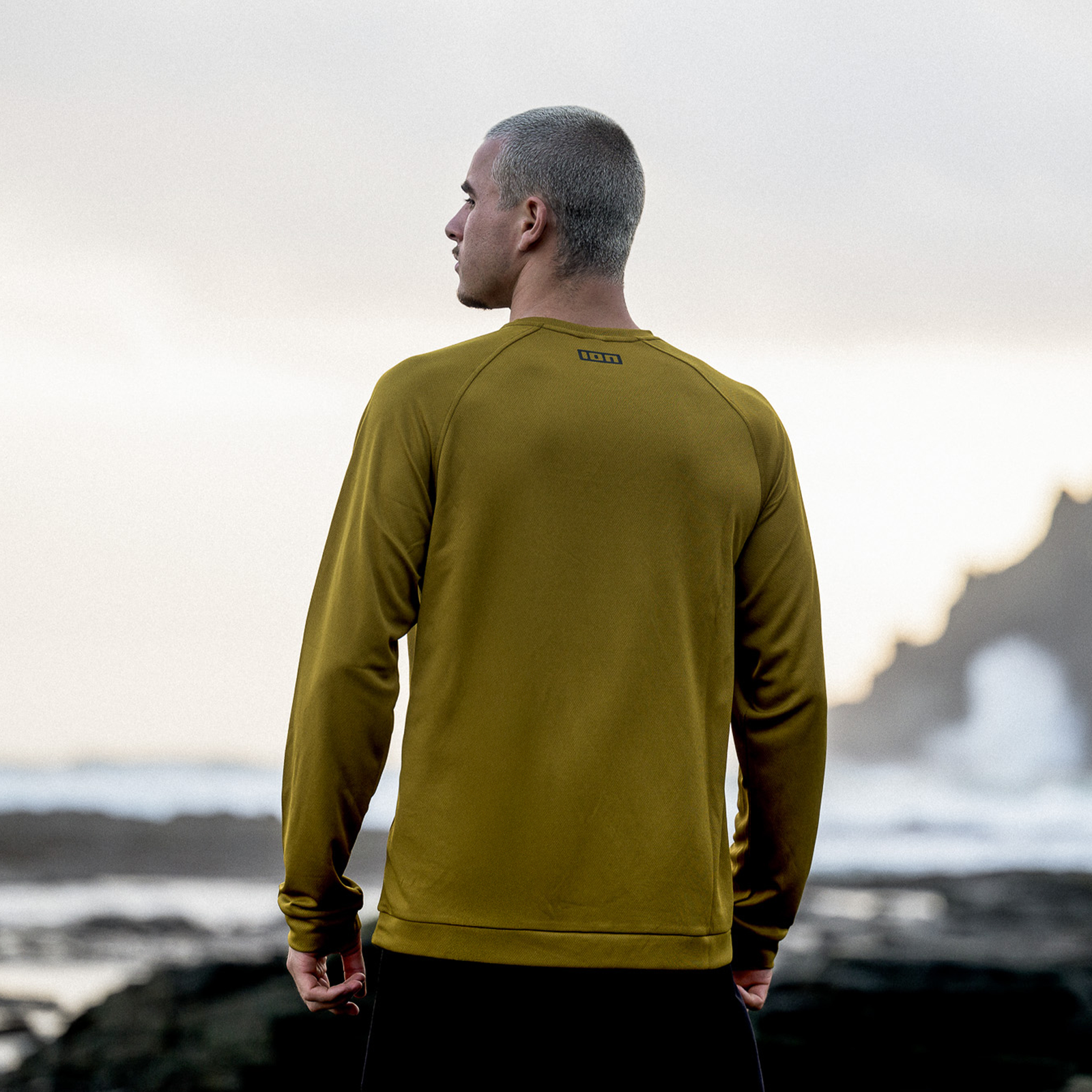 ION Wetshirt LS t-shirt manches longues homme en or olive lors de sports nautiques sur côte rocheuse