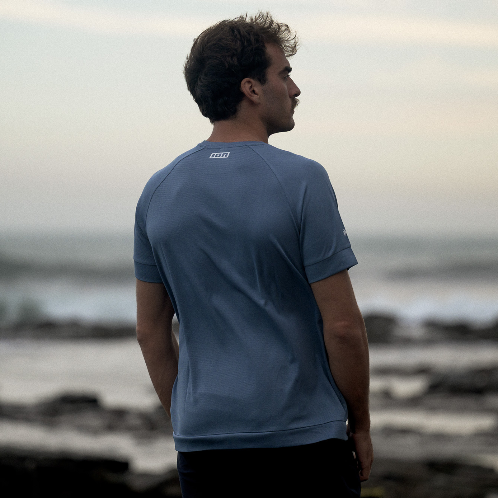 ION Wetshirt SS men short-sleeve top in slate blue during kitesurfing at the coast