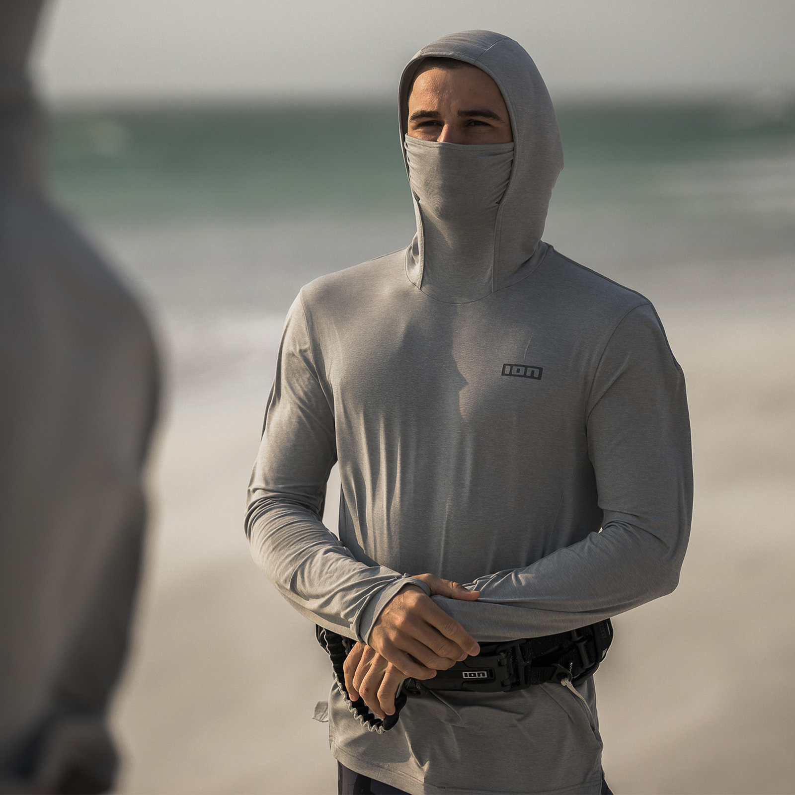 ION Storm Pro long-sleeve hooded wetshirt with face mask in light grey at the beach