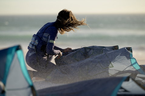 ION Sol Curv seat harness in navy with CURV hard shell during kitesurfing at the beach