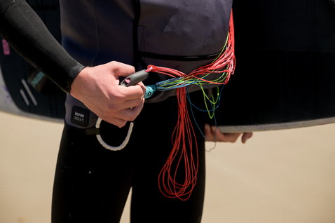 ION Water Jacket Neo Jam veste néoprène en noir lors d'une session de parawing sur la plage