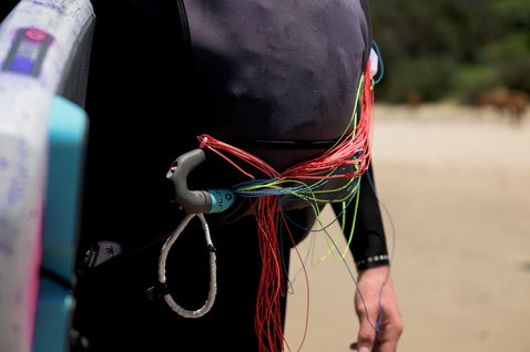 Veste néoprène ION Water Neo Jam lors d'une session de parawing sur la plage en noir