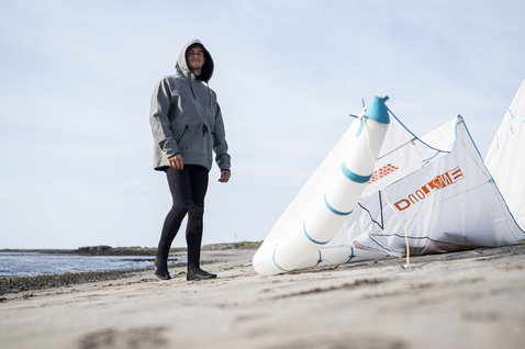 ION Neo Hoody Lite sweat à capuche en néoprène gris clair lors d'une session de kitesurf sur la plage