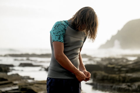 ION Neo Top 2/2 top de neoprene manga curta homem em antracite e turquesa durante desporto aquático na costa