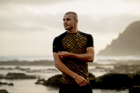 ION Maze short-sleeve men's rashguard in black and amber geometric print at the coast