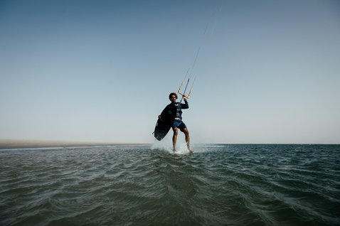 ION Water Wetshirt Hood LS Herren beim Kitesurfen auf dem Meer in dunkelgrün
