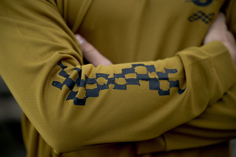 ION Wetshirt manga comprida homem em dourado oliva com estampado geométrico na manga, vista detalhe