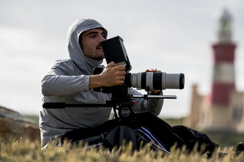 ION Storm Pro LS Wetshirt Herren in hellgrau beim Outdoor-Shooting an der Küste mit Leuchtturm