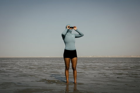 ION Sun Pro LS Rashguard Damen mit Kapuze und langem Arm in hellblau beim Wassersport an der Küste