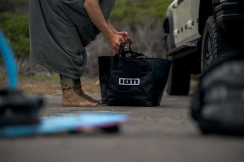 ION Changing Bucket bag in black used after a kitesurfing session at the beach
