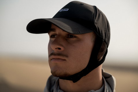 ION Water Cap casquette de surf en noir avec jugulaire, portée à la plage