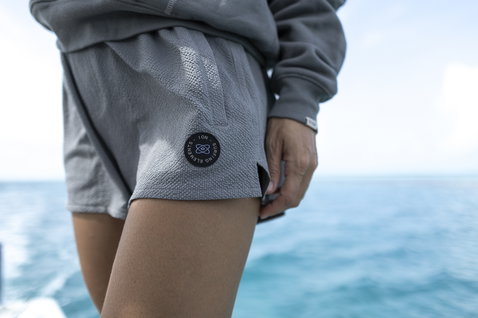 ION Tally boardshort donna 2,5" in grigio chiaro durante gli sport acquatici sull'oceano