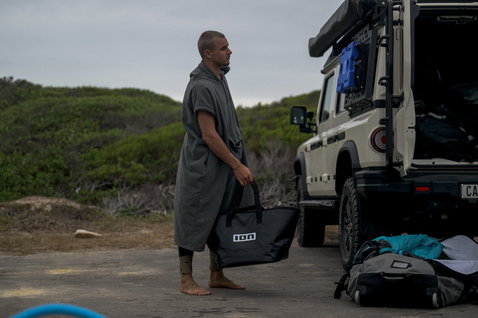 ION Element quick-dry hooded poncho in charcoal grey at the beach after a watersports session