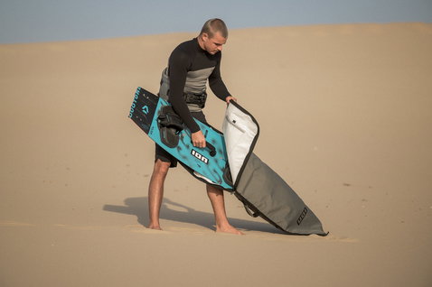 ION Core twin-tip boardbag during kitesurfing on sand dunes in taupe grey and white