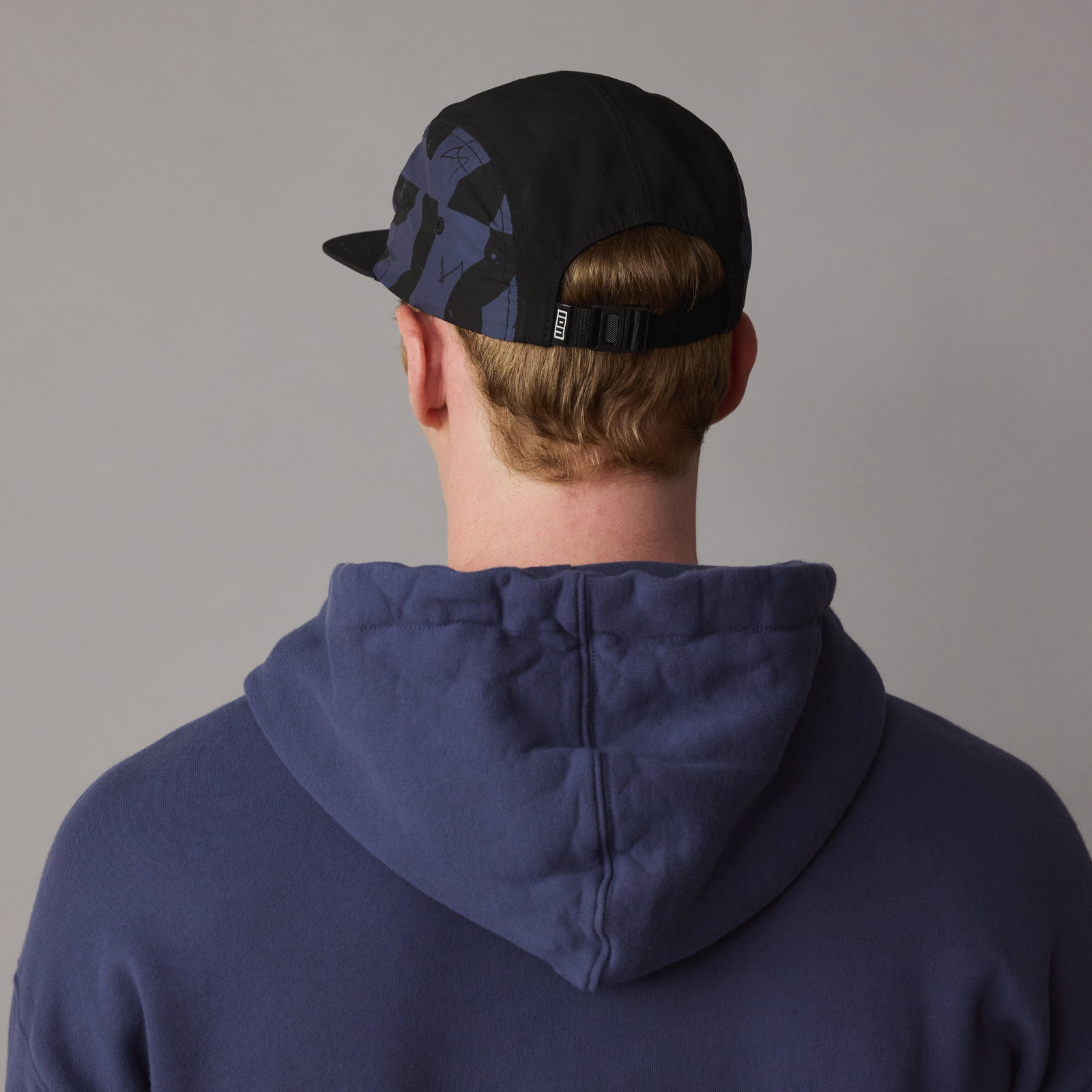 ION Refresh Light cap in black with dark navy graphic print, back view on model