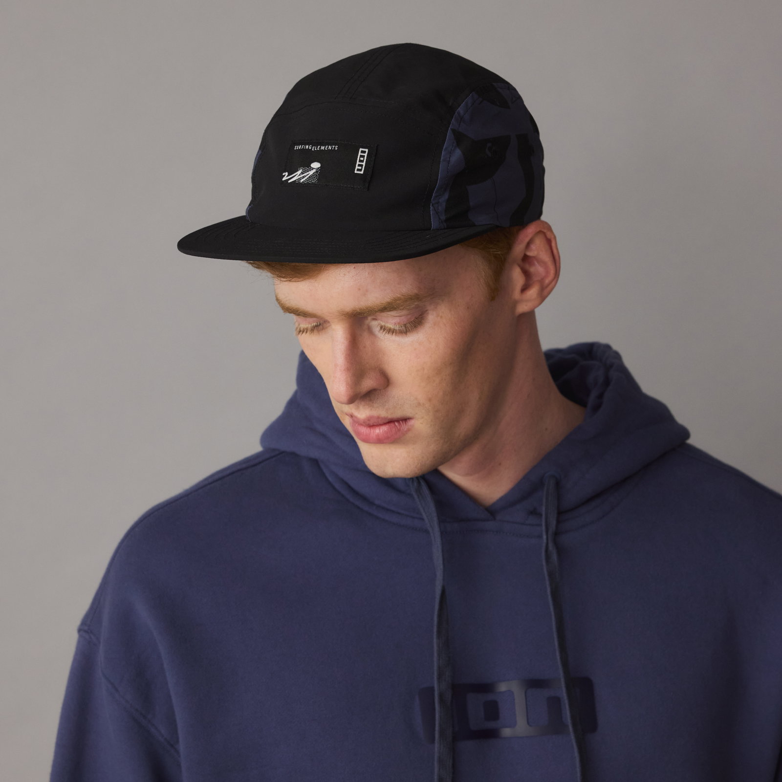 ION Refresh Light cap in black with dark navy camouflage panels, worn on model