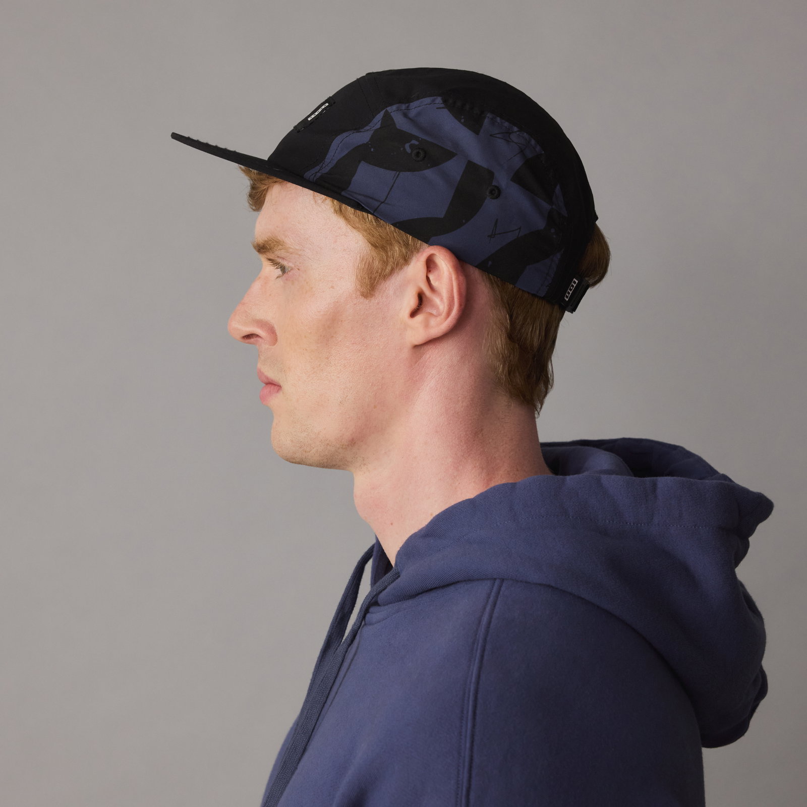 ION Refresh Light cap in black with dark navy print, side view on model
