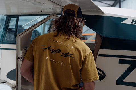ION Mood short sleeve t-shirt men in golden mustard with back graphic print in a lifestyle hangar setting