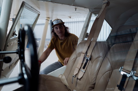 ION Mood short sleeve t-shirt men in golden yellow during lifestyle shoot inside aircraft cockpit