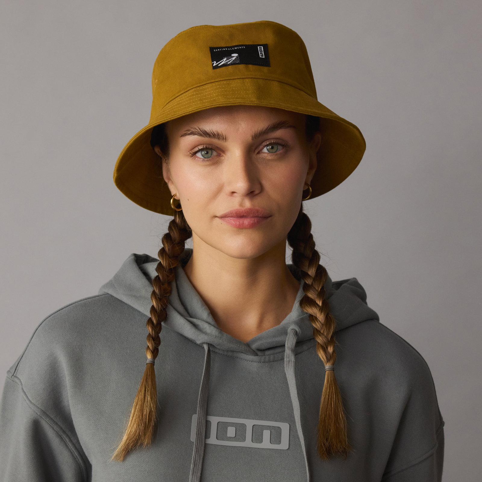 ION Cotton Bucket Hat Onesize in gold burst worn by a model in a studio setting