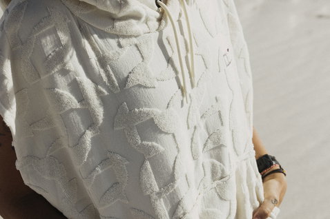 ION Poncho Select Reefside surf poncho in off-white with hood at the beach