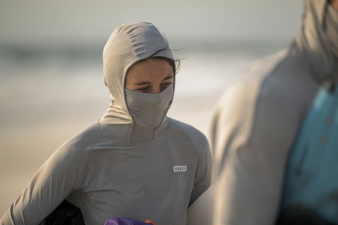 ION Wetshirt Storm Pro LS Damen Langarm-Rashguard mit Kapuze in hellgrau beim Kitesurfen am Strand
