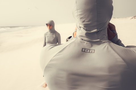 Rashguard ION Sun Pro LS homem com capuz em cinzento claro na praia, vista traseira