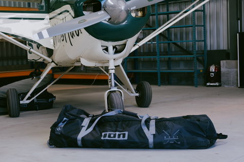 Borsa da viaggio ION Gearbag Tec Golf per kite in nero in un hangar