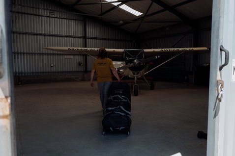 Borsa da viaggio ION Gearbag Tec Golf in nero trascinata in un hangar aereo